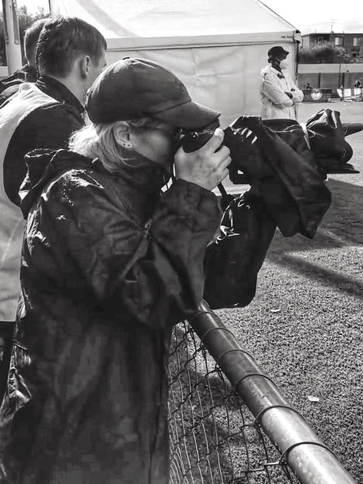 Cat Bryant shoots from from the sidelines in wet weather.