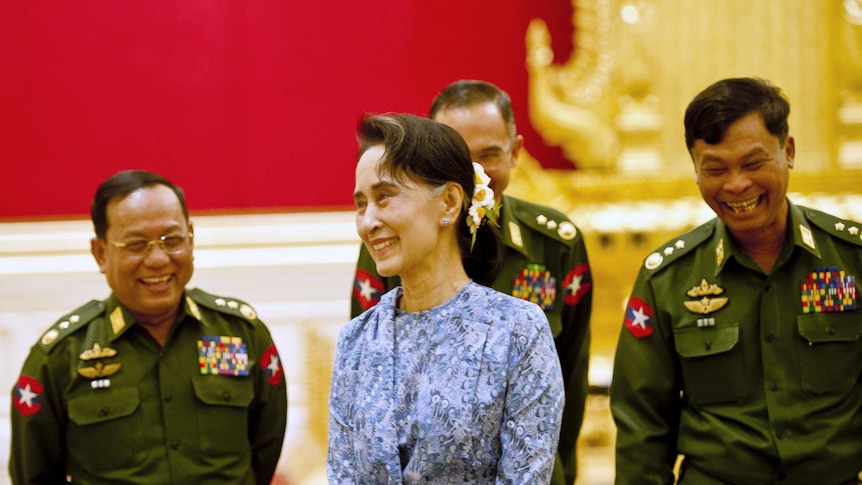 Aung San Suu Kyi smiles with army members