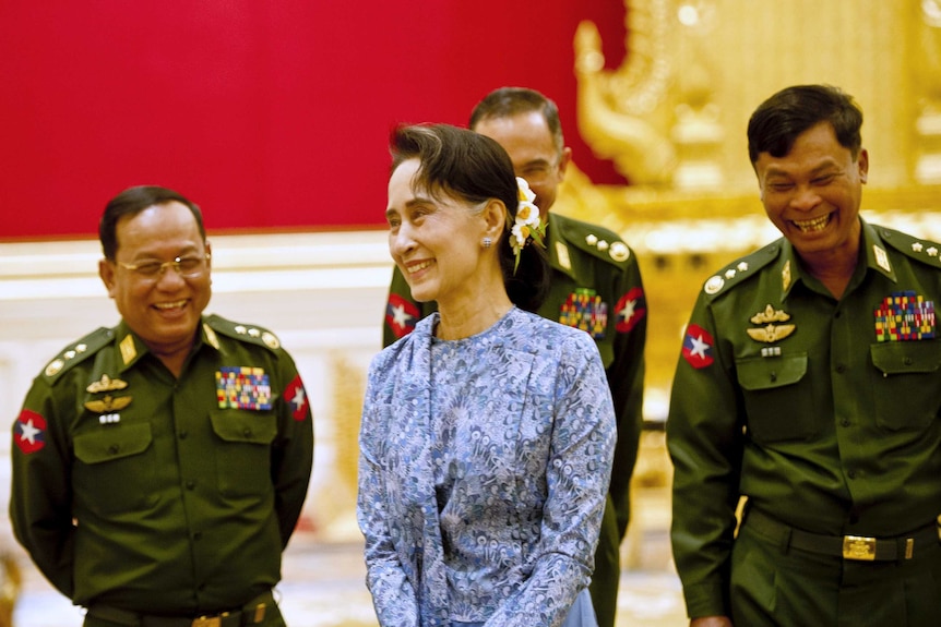 Aung San Suu Kyi smiles with army members