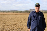 Vegetable farmer Steve Kluck stands in a dry, empty paddock.