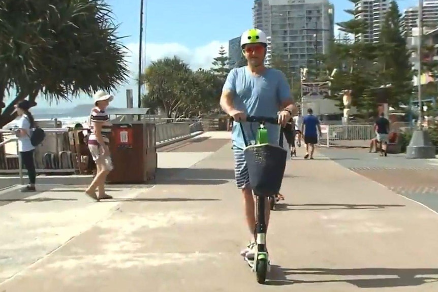 A man on an electric scooter in Surfers Paradise