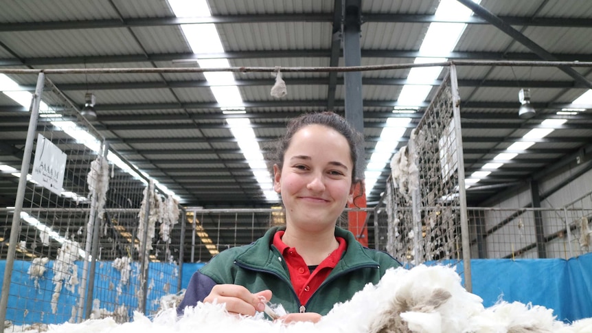 Lucy Cooper, 24, is standing in front of a wool fleece.