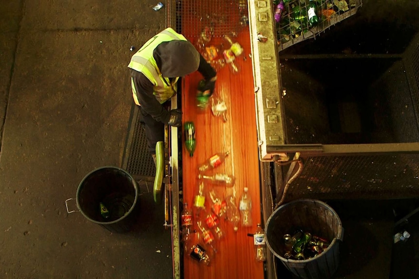 A yard hand sorts bottles at the recycling depot in Adelaide.