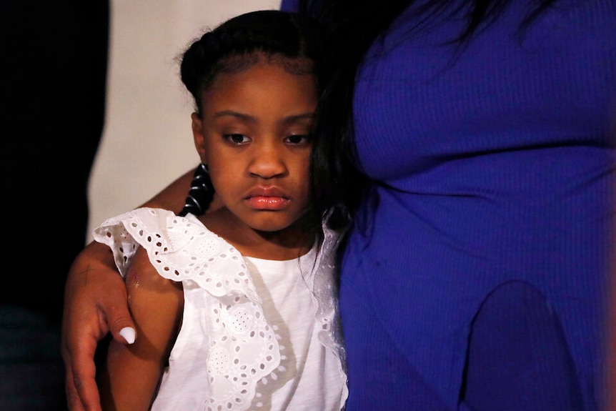 Gianna Floyd listens to a news conference.