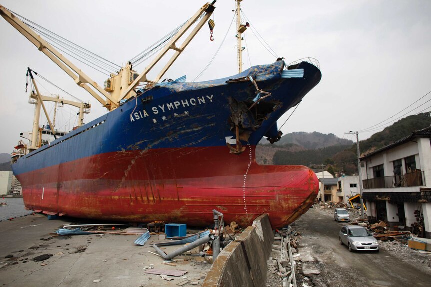 A ship swept ashore in a Japanese fishing village following tsunami.