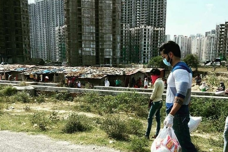 Prateek Dwivedi holding bags of food to take to vulnerable people in India. 