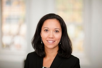 A woman wearing a blazer in front of a blurry background