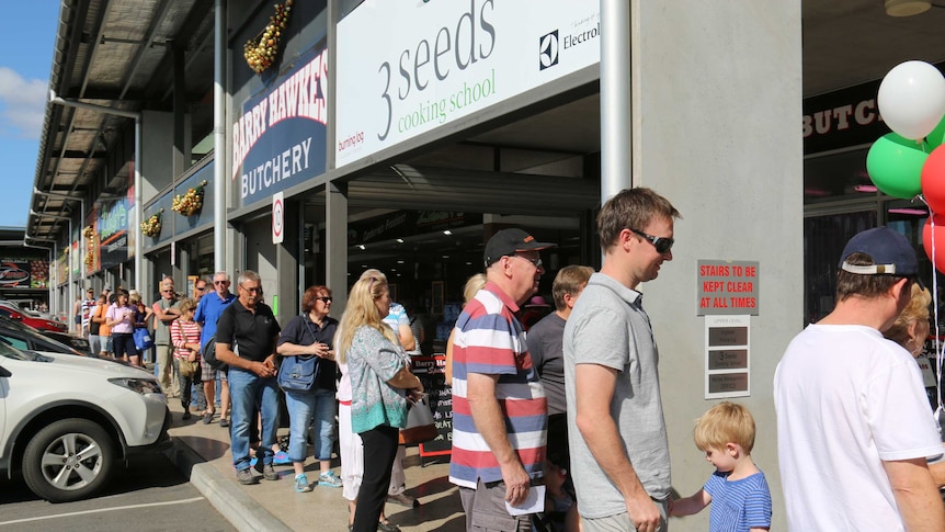 Customers queue out the door at seafood shop in Canberra.