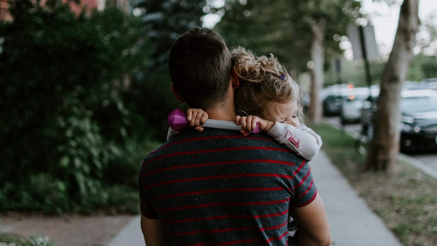 Sleeping child in father's arms.