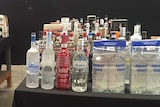 Several rows of spirits sitting on two tables.