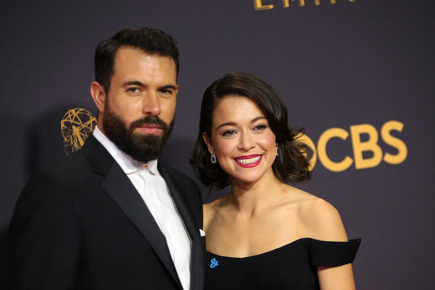 The couple wear black and smile on the red carpet