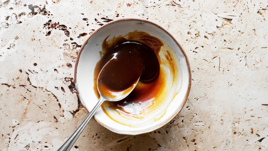 Salted caramel in a bowl with a tablespoon ready to be added to a brownie mixture.