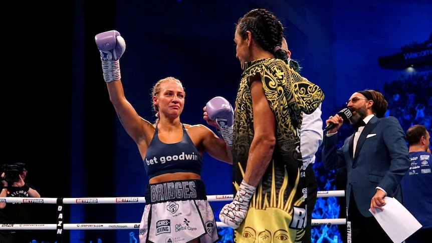 Ebanie Bridges raises her hand and looks at her opponent