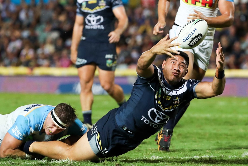 Jason Taumalolo dives for the ball while being tackled