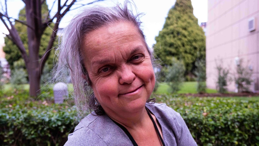 Picture of a woman outside with trees behind her.