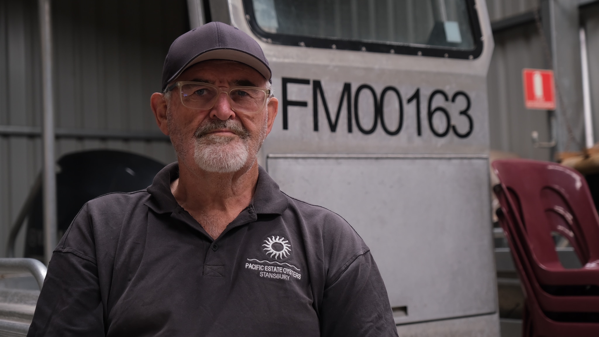 Un hombre con gafas y una gorra negra mira a la cámara.