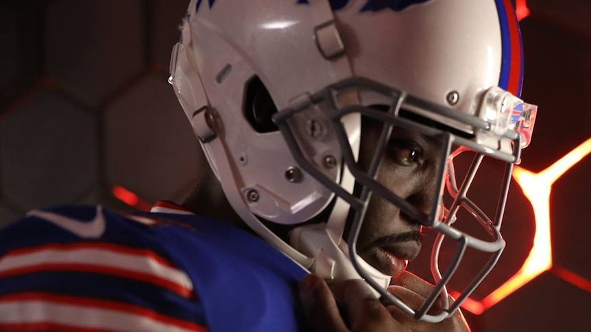 Vontae Davis looks focused, photographed from the side, wearing an american football uniform and its padding, and a helmet