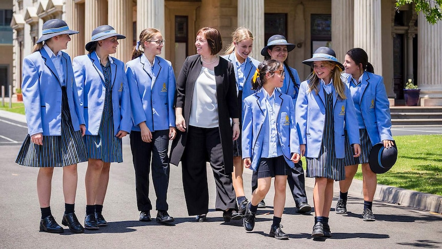 A teacher walks with teenage students in school uniform at Lowther Hall Anglican Girls Grammar School at Essendon in Victoria.