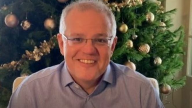 Australian Prime Minister Scott Morrison smiles in front of a Christmas tree