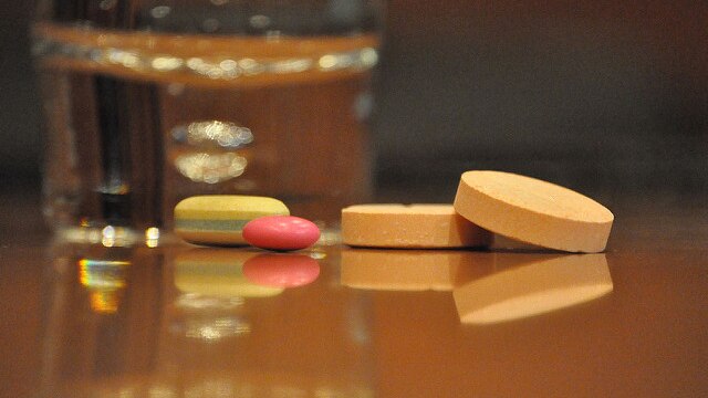 Generic image of vitamins near glass of water