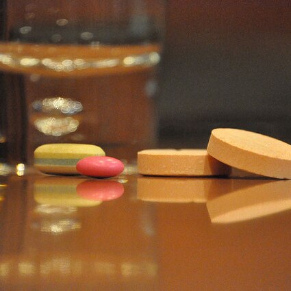 Generic image of vitamins near glass of water