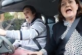 A learner driver male and his mother in the passenger seat screaming