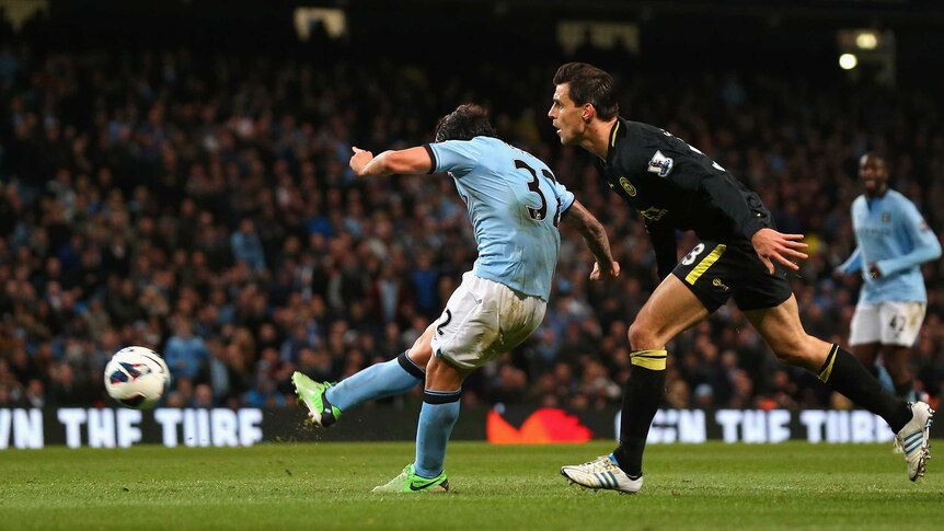 Carlos Tevez scores for Manchester City against Wigan at Eastlands.