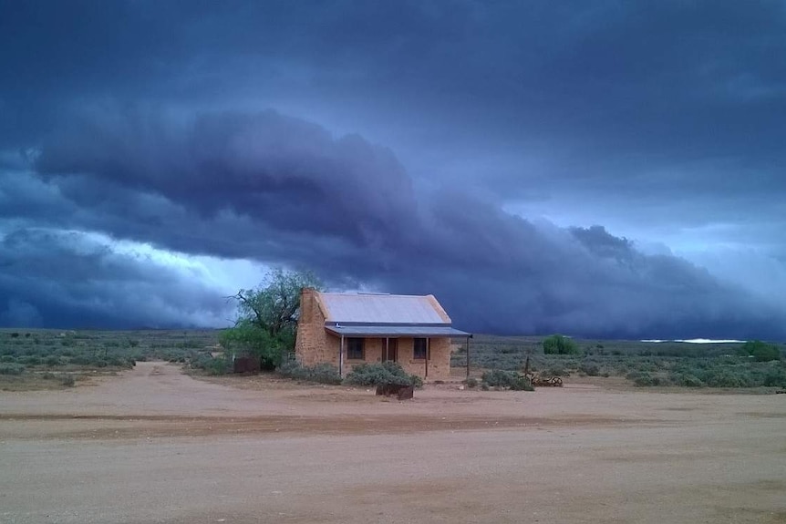 A storm looms over a small cottage in Silverton