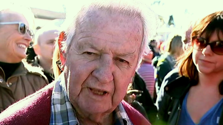 An older man speaks to the camera.