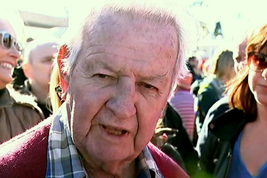 An older man speaks to the camera.