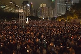 Tens of thousands of people hold candles in Hong Kong's Victoria Park.