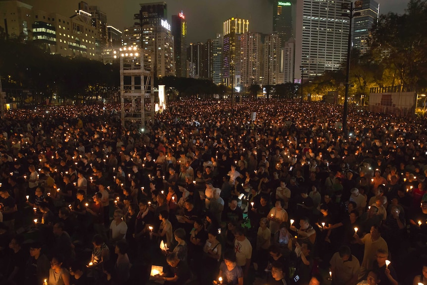 Tens of thousands of people hold candles in Hong Kong's Victoria Park.