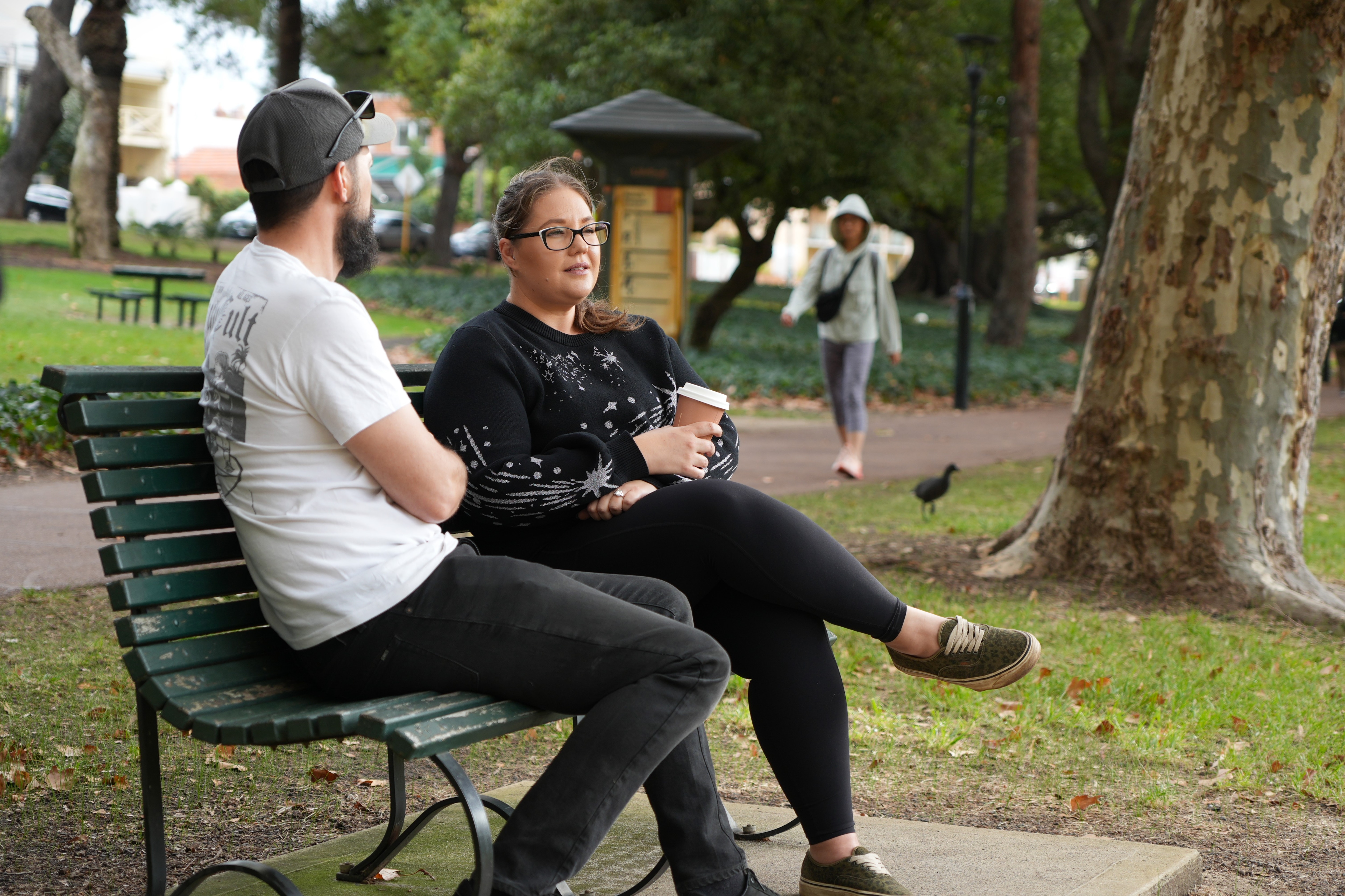 Kris Stanley sits in Hype Park wearing a black jumper and glasses.