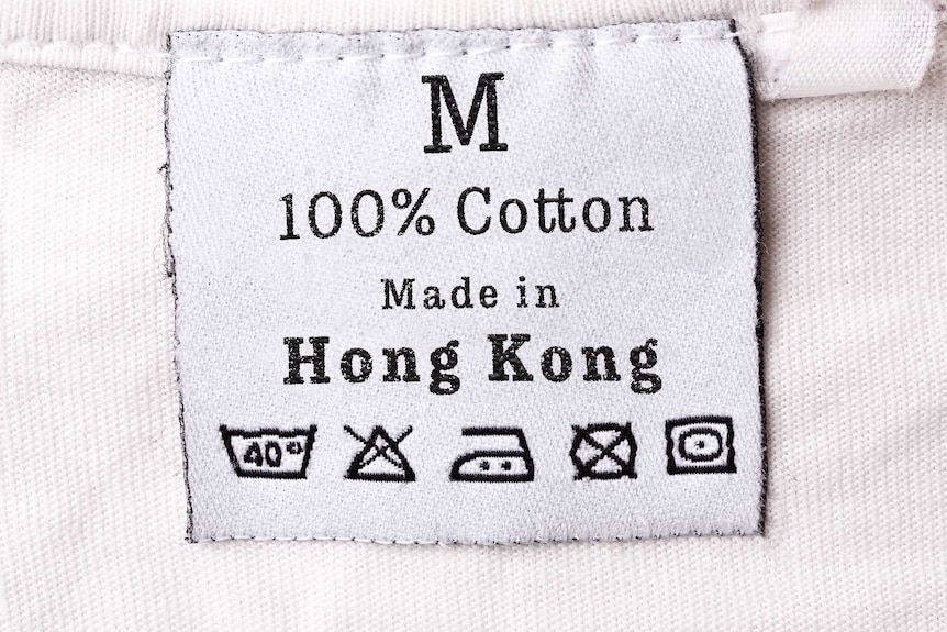 A care tag on a cotton item of clothing. It says it was Made in Hong Kong and includes symbols for care instructions.
