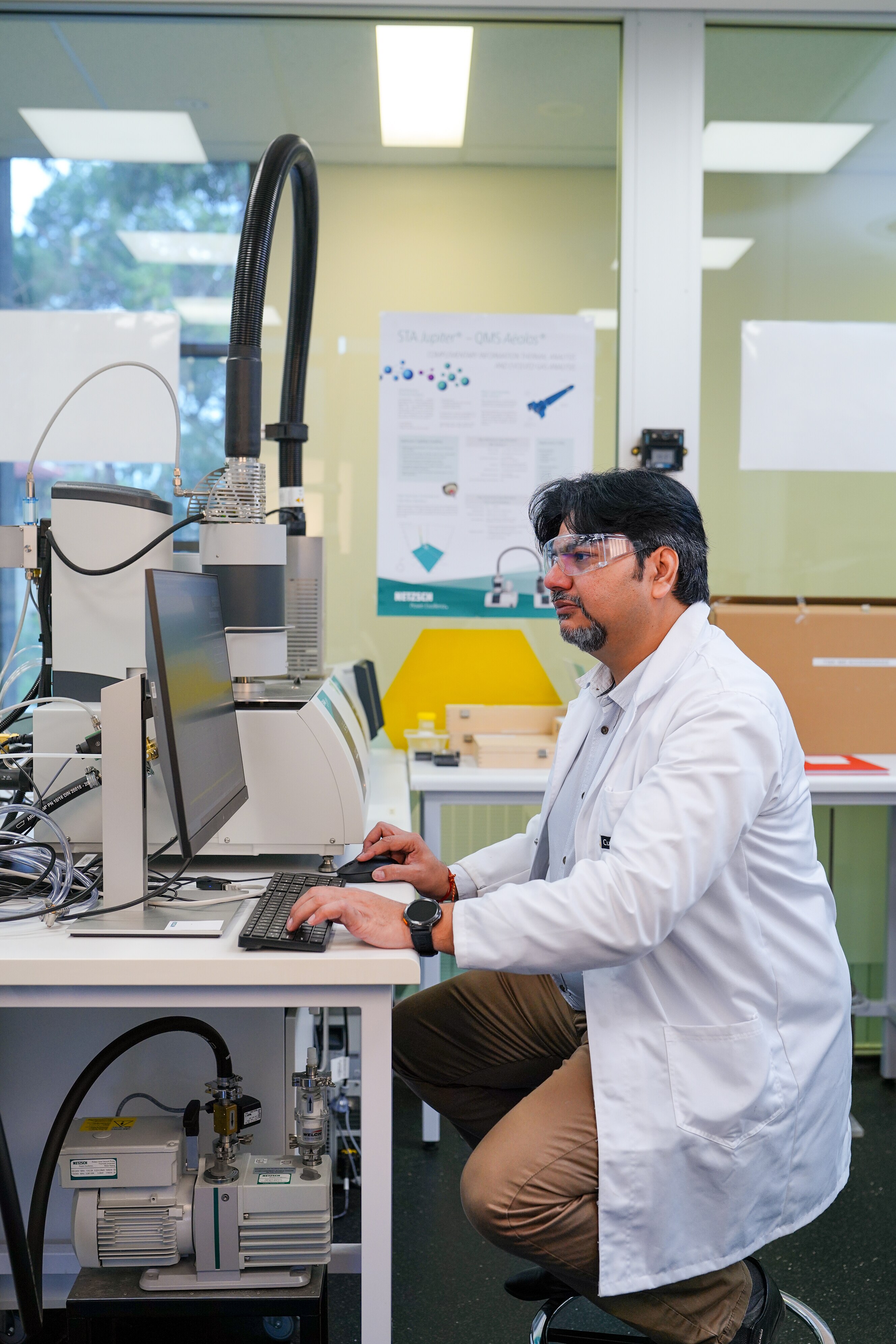 Um cientista em um laboratório diante de um computador.