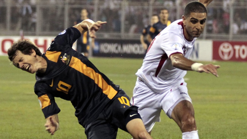 Socceroos forward Robbie Kruse is brought down by Jordan's Basem Fathi.