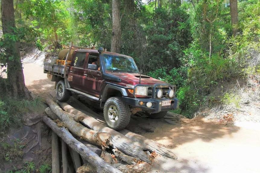 Photo of 4WD crossing a log bridge