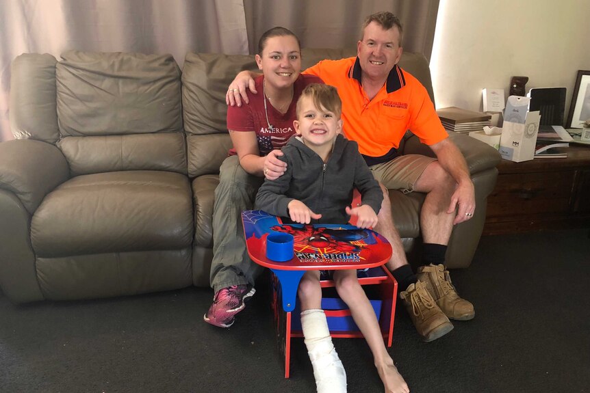 Jett Burgess with his mum and dad, back at home in Port Macquarie.