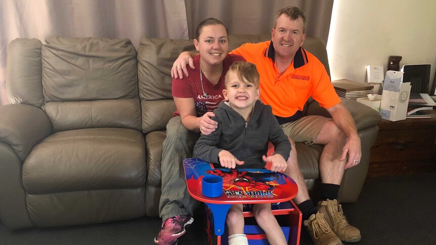 Jett Burgess with his mum and dad, back at home in Port Macquarie.