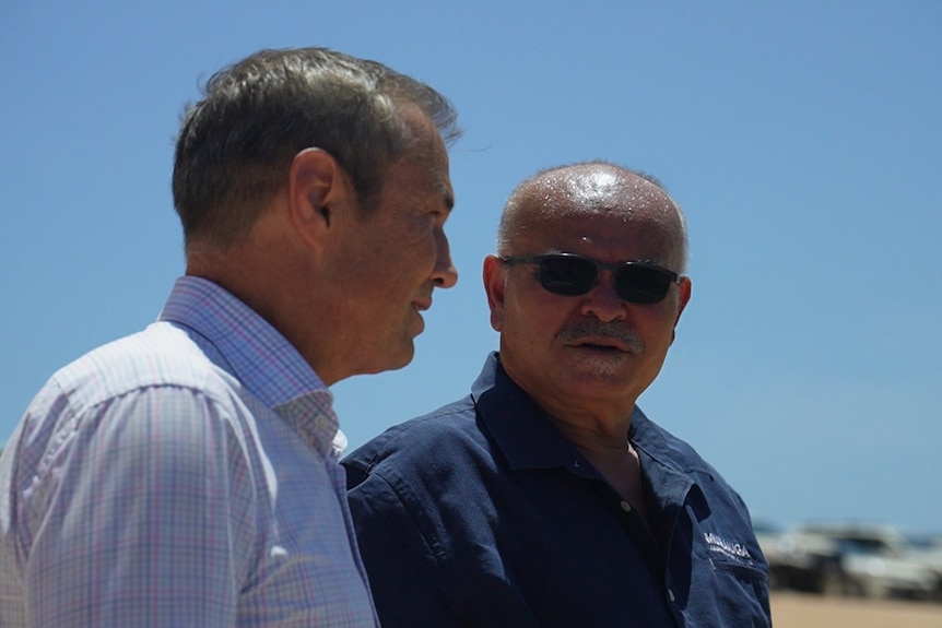 WA Premier Roger Cook standing next to Murujuga Aboriginal Corporation chair Peter Hicks at a beach.