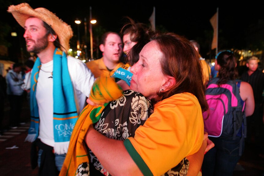 Football fans embrace after Australia eliminated