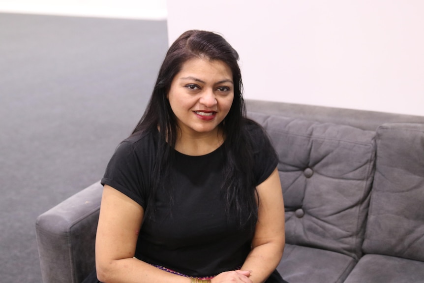 A mid-shot of Krishna Shah sitting on a couch and looking up at camera 