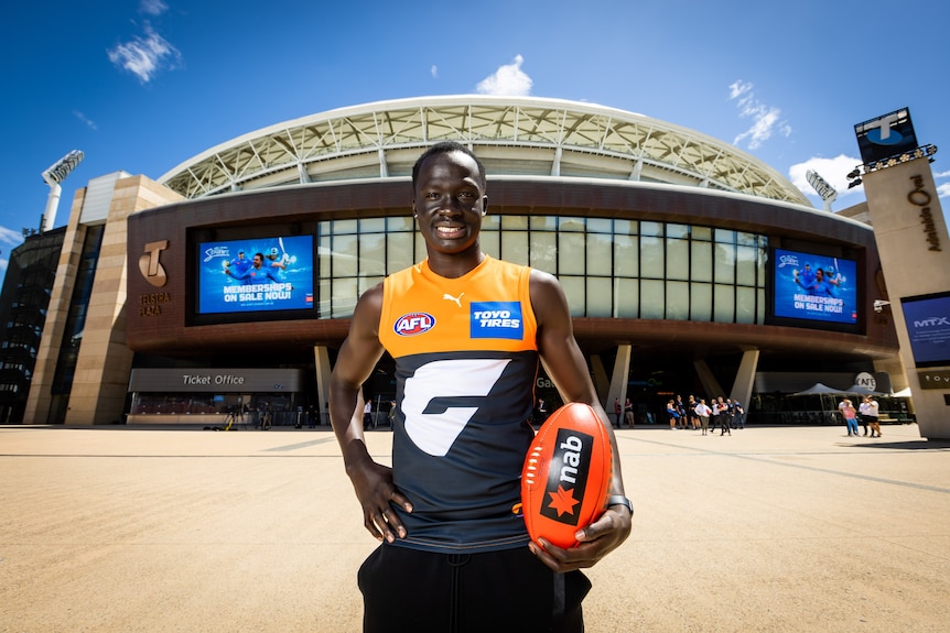  Leek Aleer dressed in football jumper and holding a football.