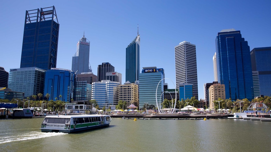 A wide shot showing a passenger ferry sailing into Elizabeth Quay with the Perth city skyline in the background.