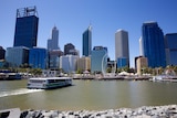 A wide shot showing a passenger ferry sailing into Elizabeth Quay with the Perth city skyline in the background.
