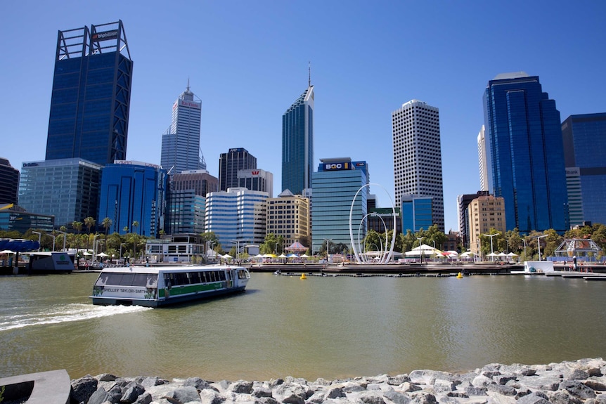 A wide shot showing a passenger ferry sailing into Elizabeth Quay with the Perth city skyline in the background.