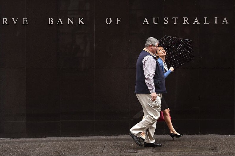 People walk past the Reverse Bank of Australia building in Sydney on November 3, 2015.
