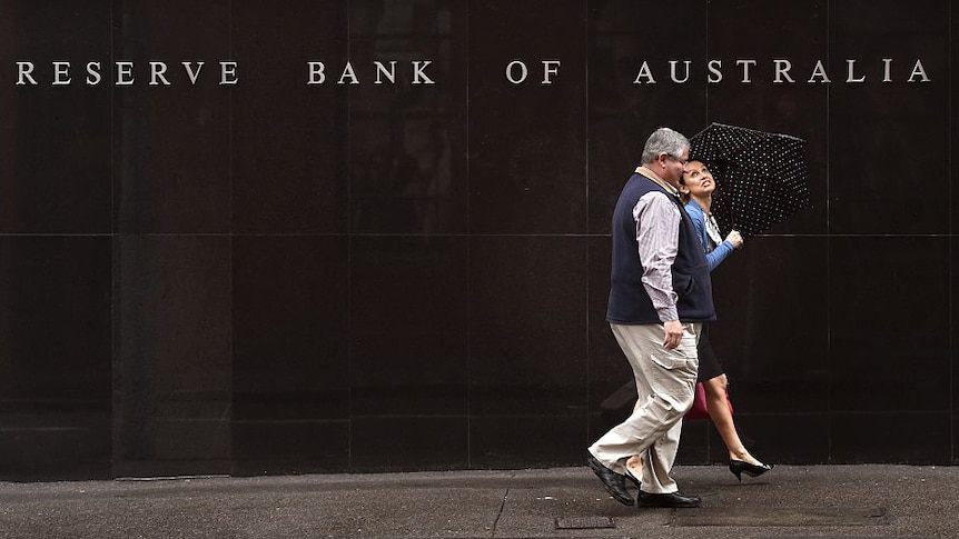 People walk past the Reverse Bank of Australia building in Sydney on November 3, 2015.