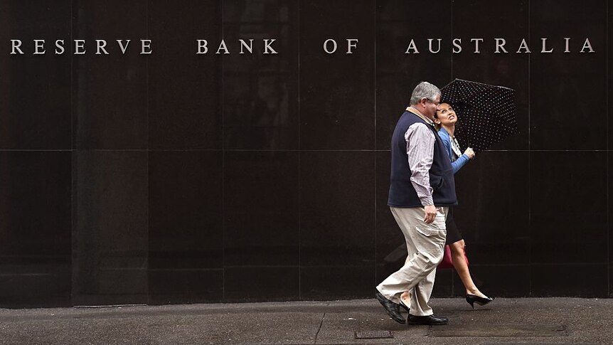 People walk past the Reverse Bank of Australia building in Sydney on November 3, 2015.