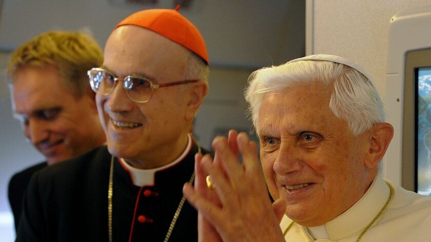 Pope Benedict gestures onboard the plane from Rome to Australia